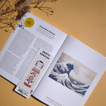 marque page kokeshi naruko posé sur livre