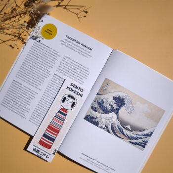 marque page kokeshi tsuchuyu posé sur livre